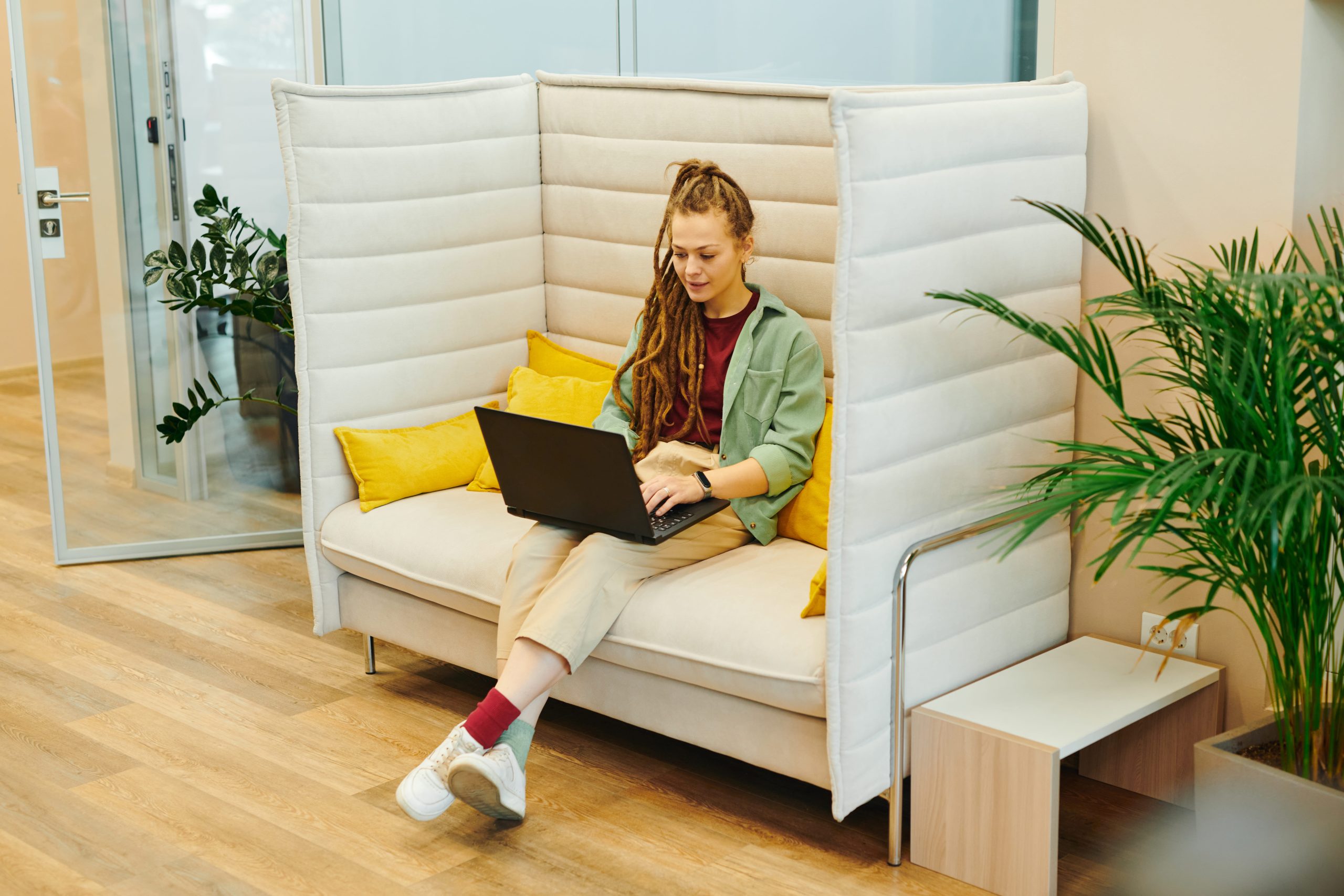 High-back office sofa with side wings creating a private acoustic zone for one-on-one meetings